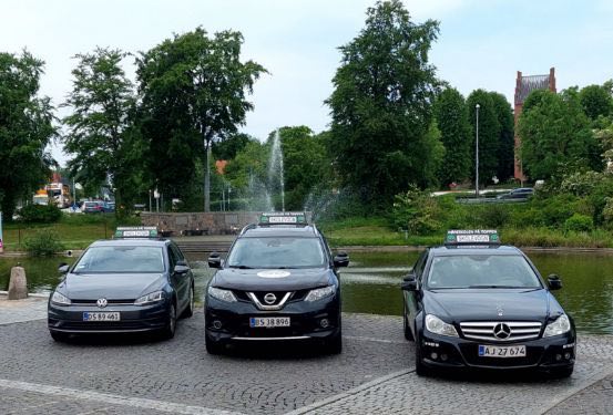 Køreskolens biler parkeret ved gadekæret i Helsinge.